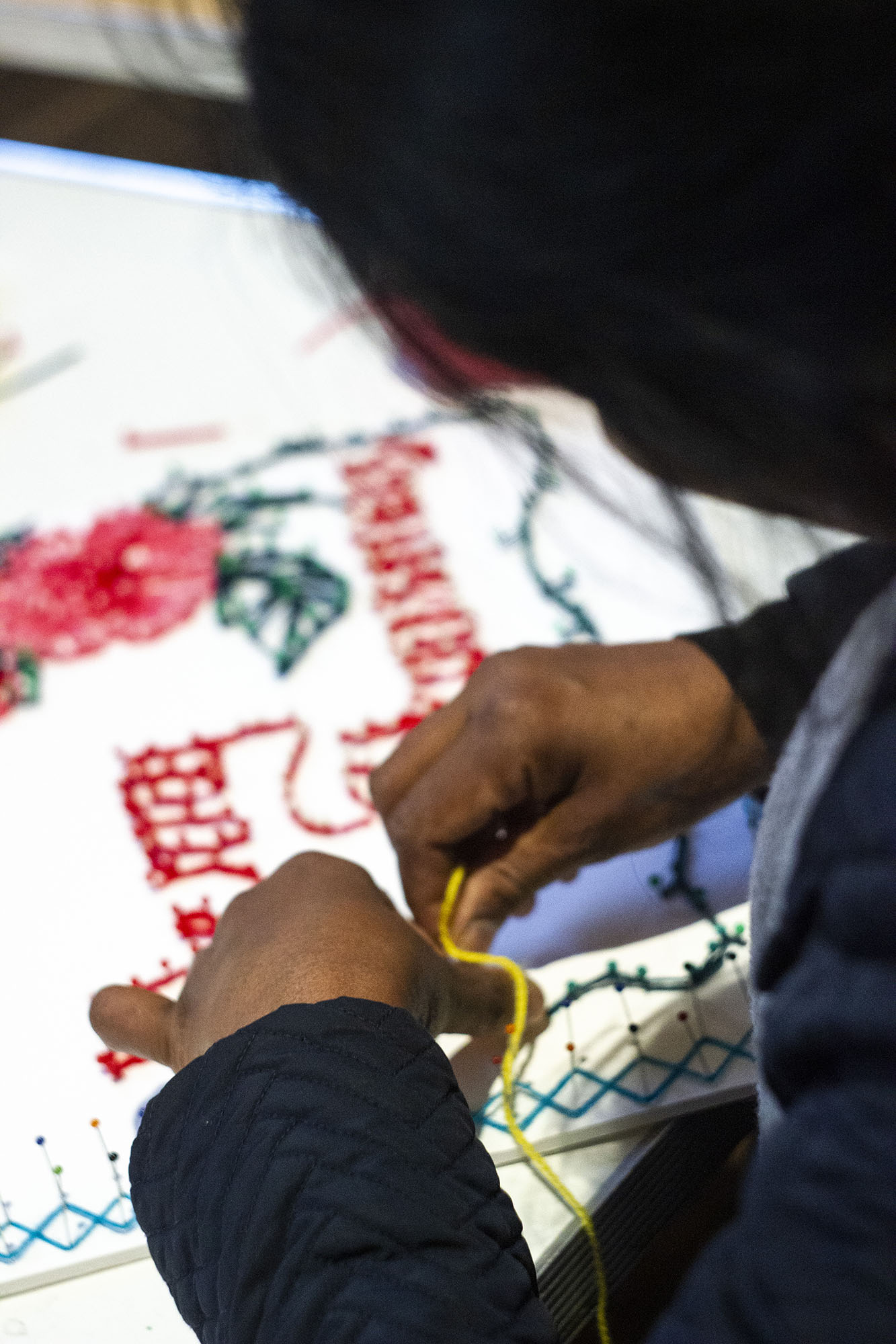 Child creating artwork of a flower and text.